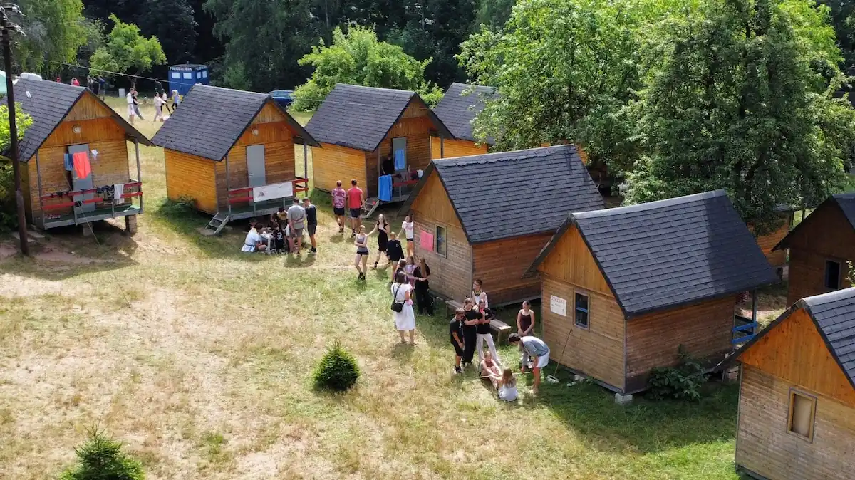 Z dronu vyfocené chatičky Horního tábora s dětmi kolem nich.